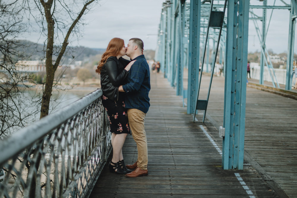 Man and woman kissing at the Walnut Street Bridge in Chattanooga, TN.