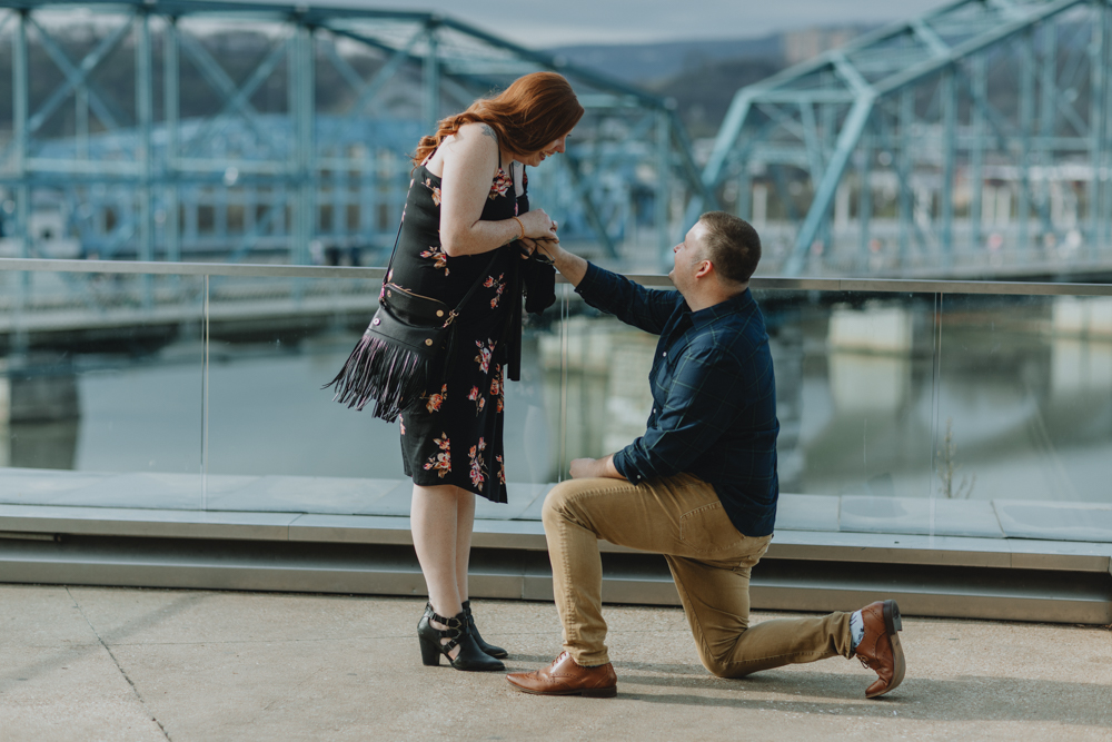 Man proposing to woman at Walnut Street Bridge in Chattanooga, TN