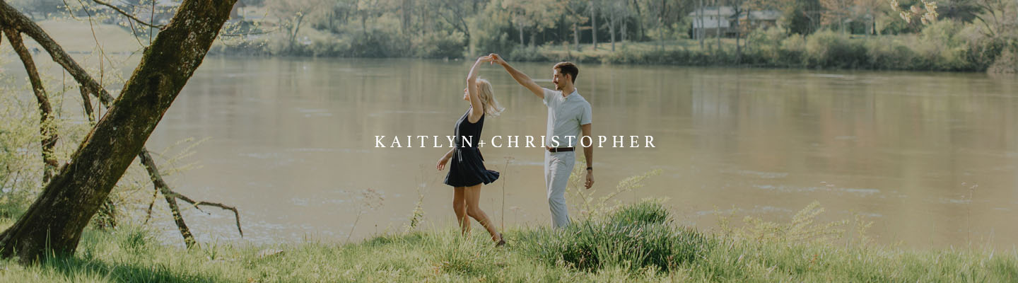 Man and woman dancing by the Tennessee River for engagement photography.